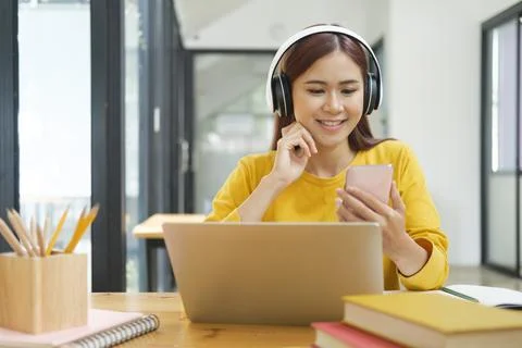 Young collage student using computer and mobile device studying online. Foto stock