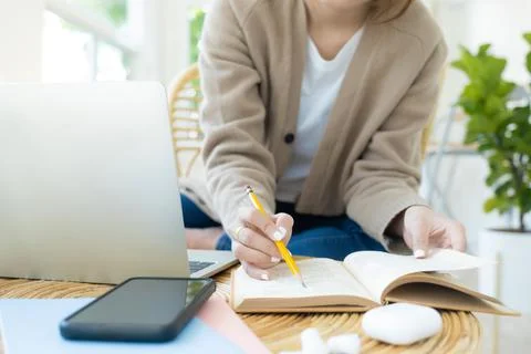 Young collage student using computer and mobile device studying online.. Stock Photos