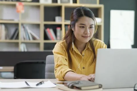Young collage student using computer and mobile device studying online. Stock Photos