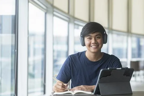 Young collage student using computer and mobile device studying Stock Photos
