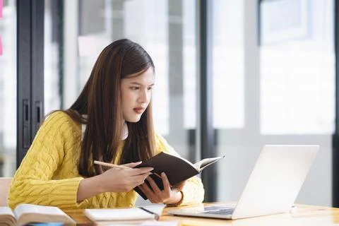 Young collage student using computer and mobile device studying Stock Photos