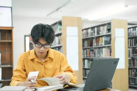 Young collage student using computer and mobile device studying online. 写真素材
