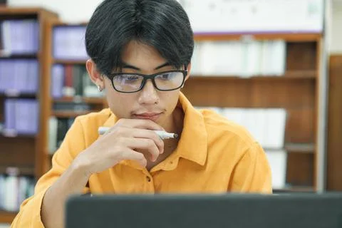 Young collage student using computer and mobile device studying online. Stock Photos