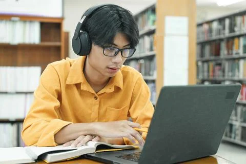 Young collage student using computer and mobile device studying online. 写真素材