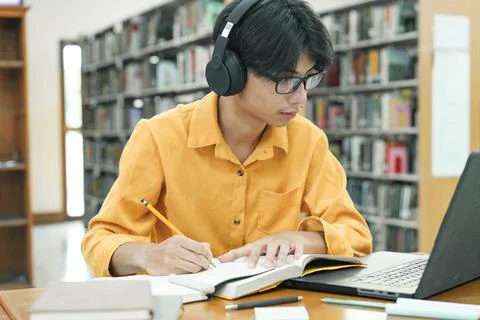 Young collage student using computer and mobile device studying online. 写真素材
