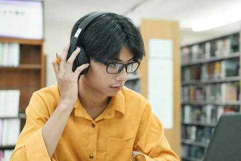 Young collage student using computer and mobile device studying online. Stock Photos