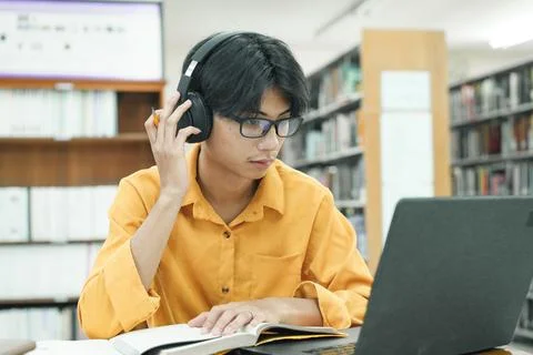 Young collage student using computer and mobile device studying online. 写真素材
