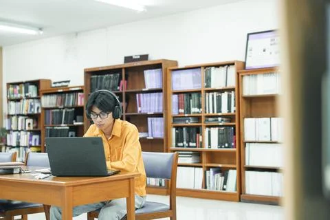 Young collage student using computer and mobile device studying online. 写真素材