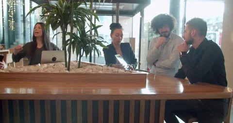 Young colleagues discussing a start up project in a coffee bar at lunch break Stock Footage 136812656