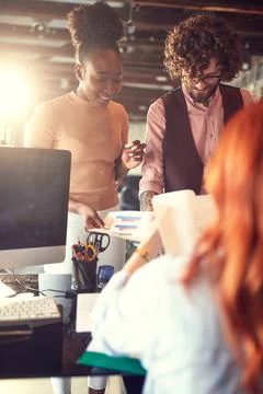 Young colleagues looking and analyzing statistic reports together Stock Photos