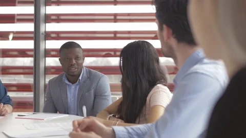 Young colleagues sharing their ideas in a meeting in start-up company Stock Footage 73883374