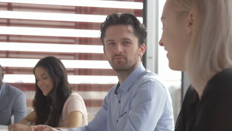 Young colleagues sharing their ideas in a meeting in start-up company Stockbeeldmateriaal 73884498