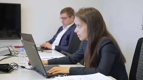 Young colleagues is working, sitting at table with laptops in company. Stock Footage 83107284