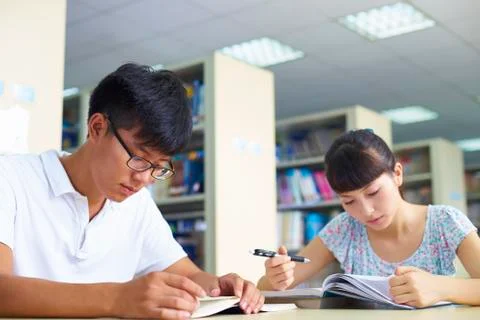 Young college students study together in the library Stock Photos