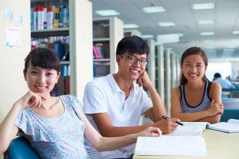 Young college students study together in the library Stock Photos