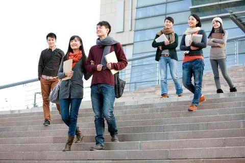 Young college students walking down steps of university building Fotos de archivo