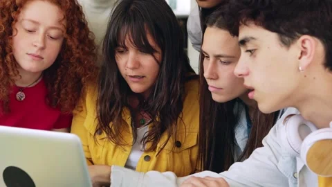 Young college students working together on laptop at campus library Stock Footage 243733618