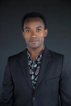 Young comedian actor casting studio portrait in black suit and shirt handso.. Stock Photos