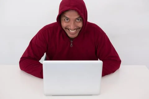 A young computer geek working online. Hacker wearing a hooded top using lapto 스톡 사진