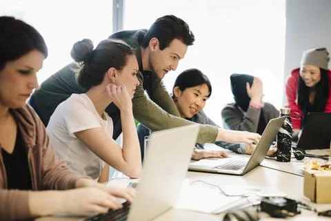 Young computer programmers coding at laptops in conference room 스톡 사진