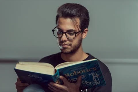 Young computer science student reads an advanced robotics book in Caceres, Spain Stock Photos