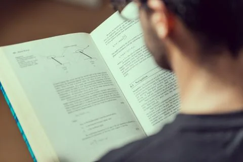 Young computer science student reads an advanced robotics book in Caceres, Spain Stock Photos