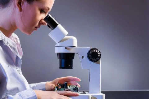 Young computer technician examining a printed circuit board. Microchip produc Foto stock