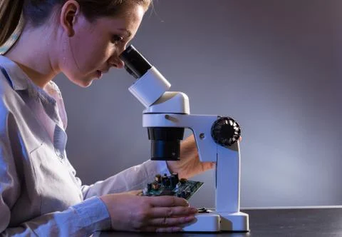 Young computer technician examining a printed circuit board. Microchip produc Foto stock