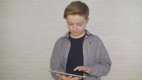 Young, conceived boy using touchscreen tablet technology and reading. Stock Footage 84230924