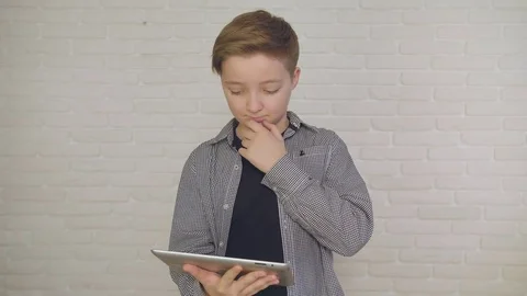Young, conceived boy using touchscreen tablet technology and reading. Stock Footage 84232017