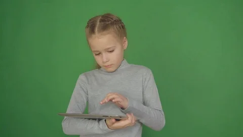 Young, conceived girl using touchscreen tablet technology and reading. 4K Stock Footage 84728097