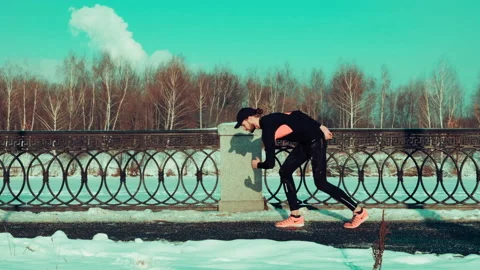 Young concentrated bearded man preparing to run on the street Stock Footage 140773279