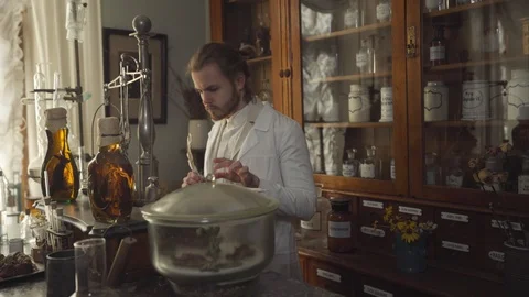 Young concentrated man checking medicines in ancient pharmacy. Guy writing with Stock Footage 120722148