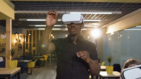 Young concentrated man in virtual reality VR glasses working in the office. Vidéo 113073217