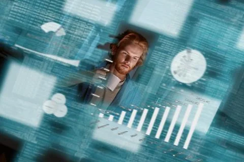 Young concentrated red haired data analyst looking over the data Stock-Fotos