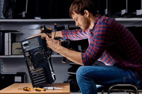 Young concentrated technician fixing a computer Stock Photos