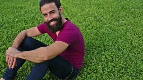 Young confident bearded man on the grass in a park Stock-Footage 59231213