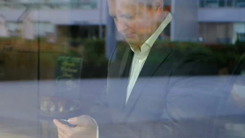 Young confident businessman holding smart phone, outside Stock-Footage 93407553