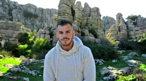 Young confident handsome man posing and smiling in nature on a sunny day.Close 스톡 동영상 58623063