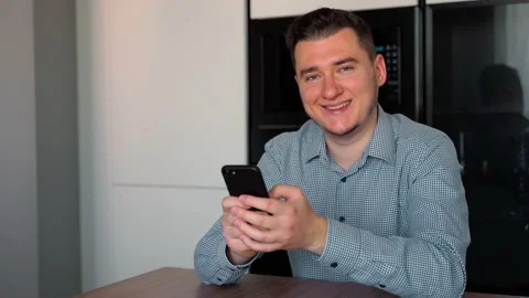 Young confident man typing smart phone then looking to the Camera confidently Stock Footage 153974408
