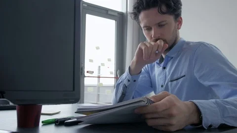 Young confident manager helping an employee with a task on tablet. Stockbeeldmateriaal 82230945