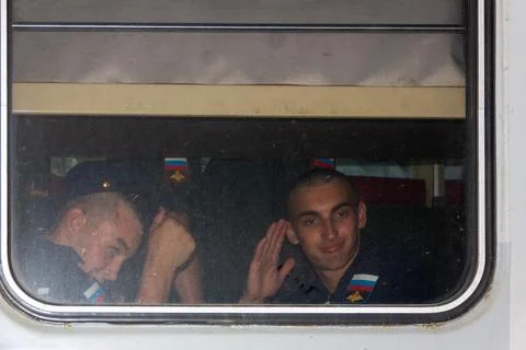 Young conscript soldiers sit in a train carriage Stock Photos