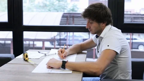 A young construction engineer is engaged in blueprints Stock Footage 82160352