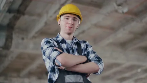 A young construction engineer in a helmet and overalls, a great design for any Video stock 130775777
