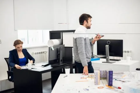 A young construction engineer is talking to someone using the sp Stock Photos
