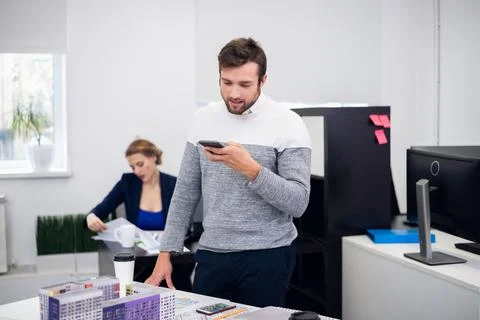 A young construction engineer is talking to someone using the sp Stock Photos