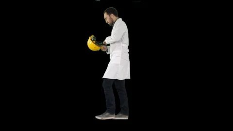 Young construction engineering student walking and putting cap on, Alpha Channel Stock Footage 105379748