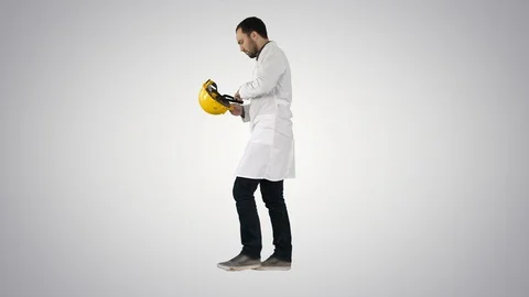 Young construction engineering student walking and putting cap on on gradient Stock Footage 114393750