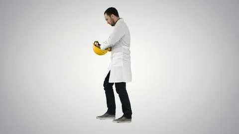 Young construction engineering student walking and putting cap o Stock Photos