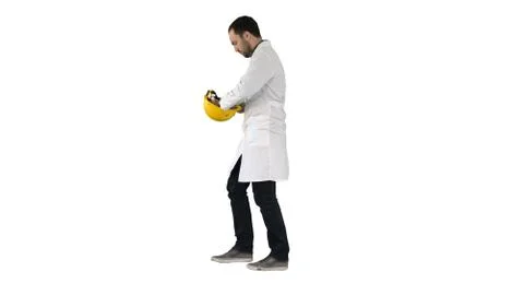 Young construction engineering student walking and putting cap o Stock Photos